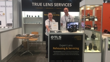 Two staff members standing behind a booth